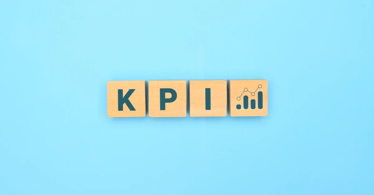 Retail KPI concept with wooden blocks spelling KPI and a bar chart icon on a blue background.